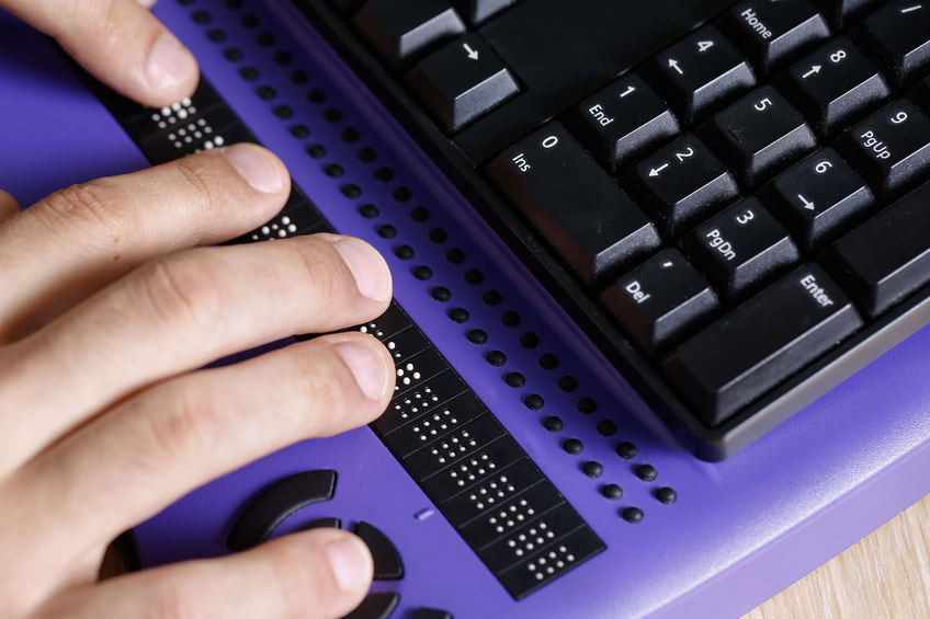 brailleleesregel met toetsenbord en deel van een hand