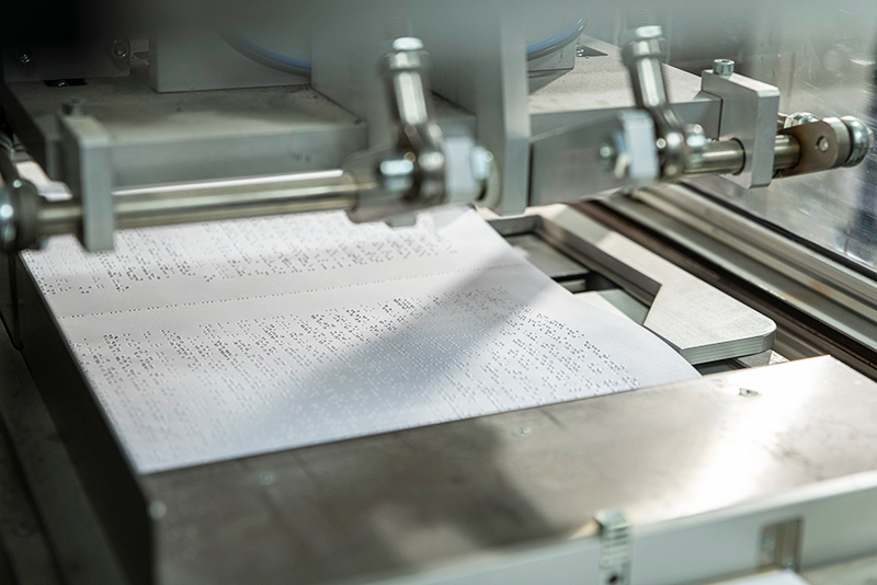 vel papier met braille rolt uit de drukpers
