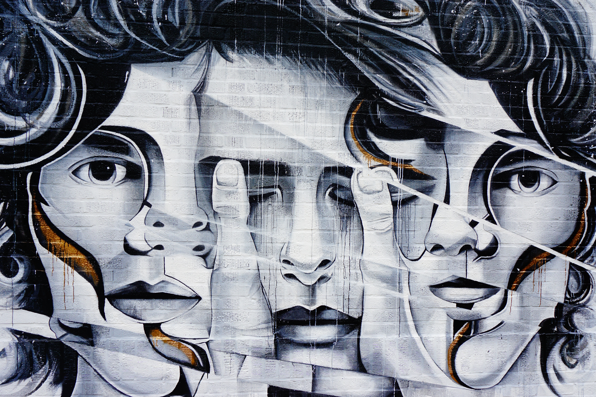 3 abstracte gezichten in graffiti op een muur