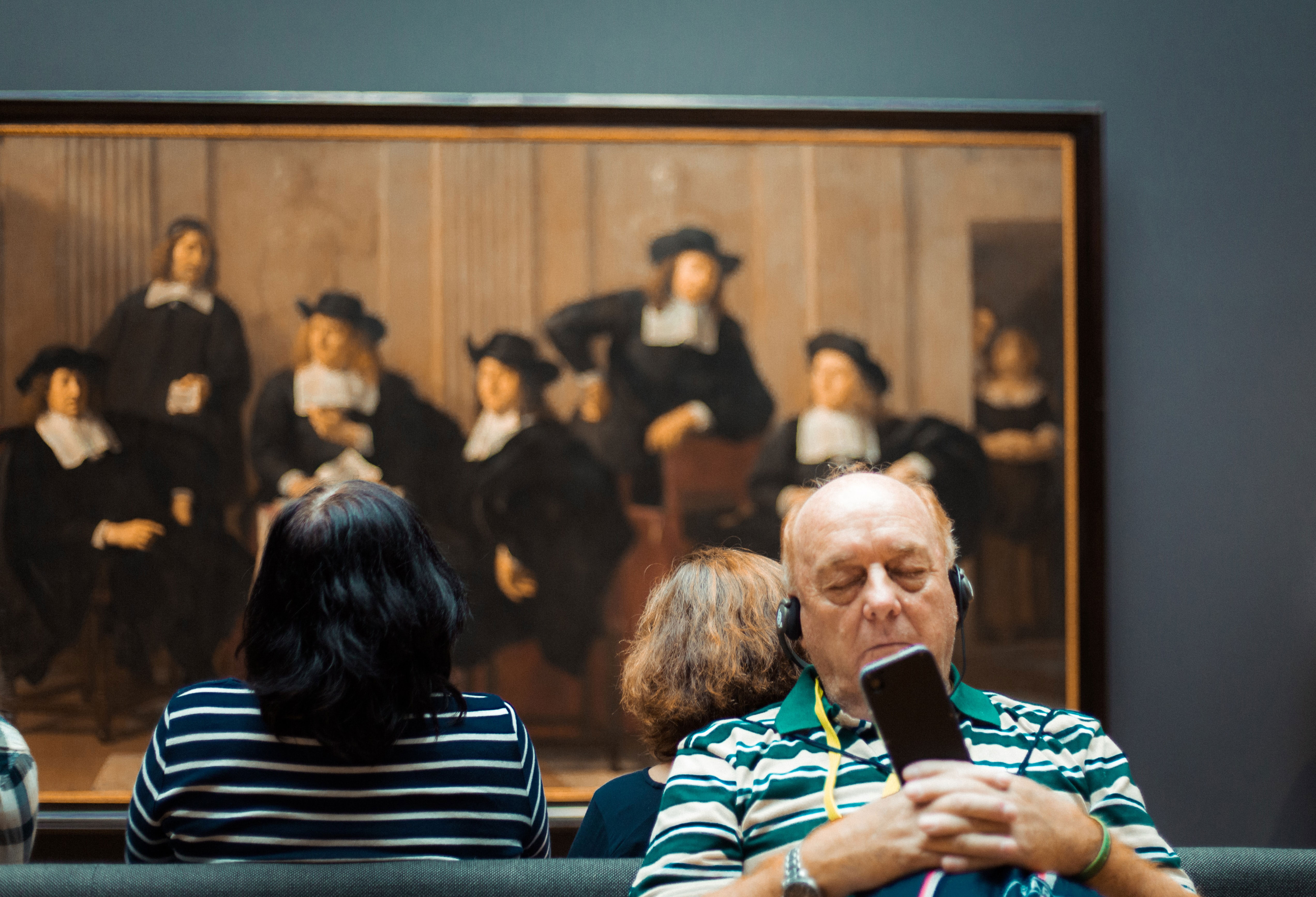 man met koptelefoon in Rembrandthuis voor een groepsportret door Ferdinand Bol