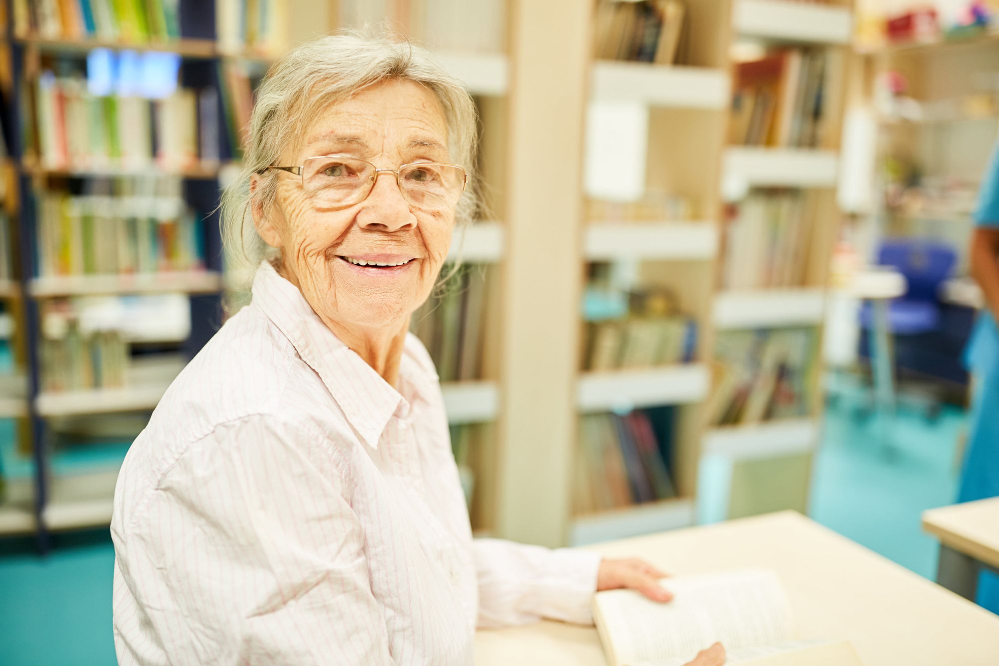 lachende oude vrouw in bibliotheek