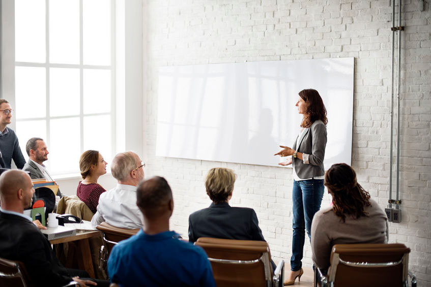 mensen in klaslokaal waar docent presenteert