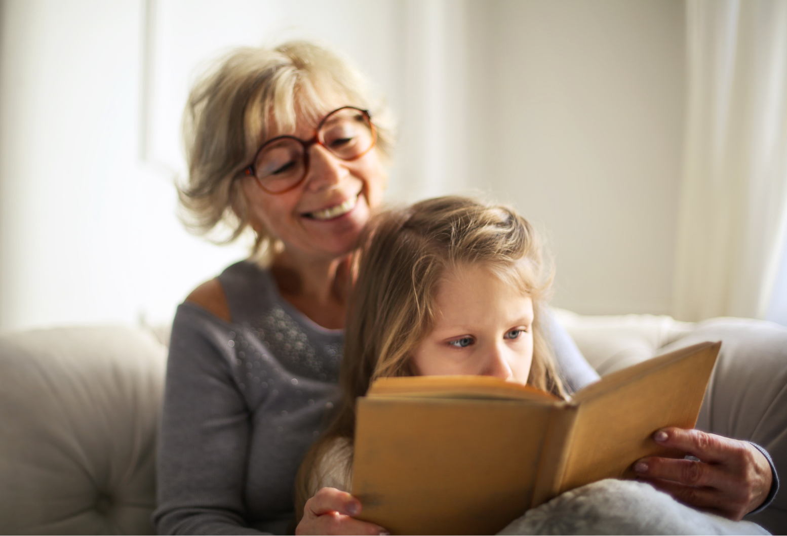 vrouw leest met meisje op schoot