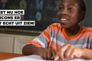 Een jongen zit aan een tafel in een klaslokaal en leest een brailleboek. Quote: 'Ik weet nu hoe emoticons er in het echt uit zien!'