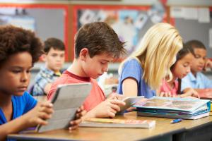 kinderen in een klas die op een tablet aan het lezen zijn