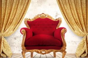 Rode koninklijke zetel voor een raam met gedrapeerde gordijnen aan weerskanten