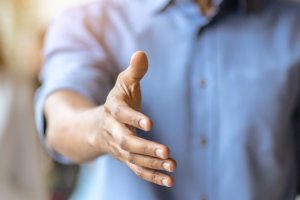 foto van een persoon (deels te zien) met uitgestoken hand