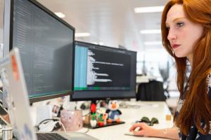 Een vrouw werkt achter een computerscherm