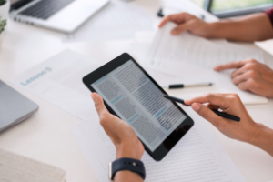 afbeelding van ipad die vastgehouden wordt. De ipad toont een tekst op het scherm.