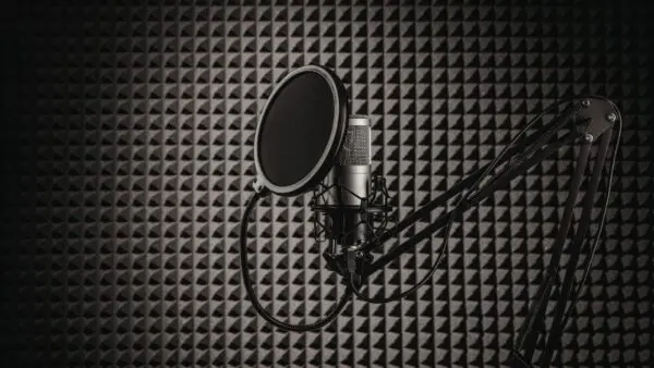 een professionele microfoon in een donkere opnamestudio