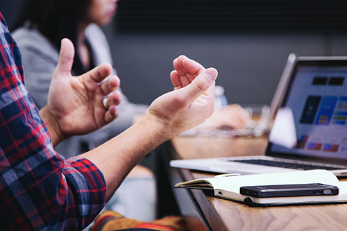 gebarende handen, schrift met mobiel en laptop