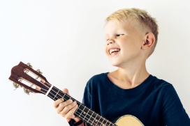 Jongen bespeelt de ukelele
