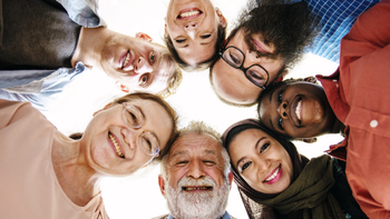 groep mensen kijkt van bovenaf lachend in de cameralens
