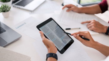 afbeelding van ipad die vastgehouden wordt. De ipad toont een tekst op het scherm.