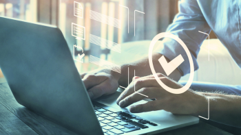 Close-up van handen en een laptop met een checkmark (vinkje) erbij